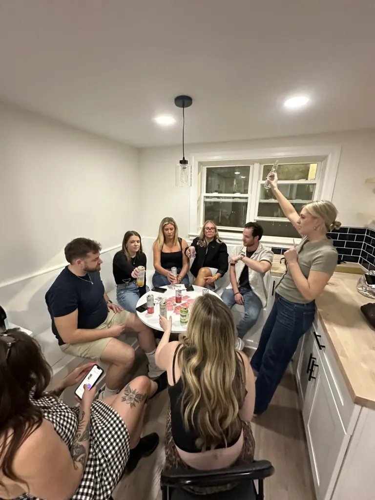 A candid group gathering around the completed kitchen breakfast nook.